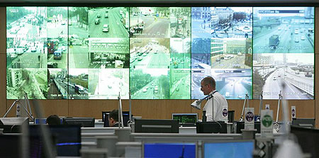 A police officer walks past screens as the Metropolitan Police open their Central Command Centre in Lambeth, south east London to the press ahead of the G20 Summit in London, on March 31 2009.